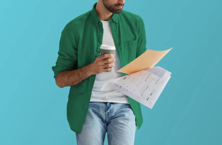 Person reading paperwork while drinking coffee